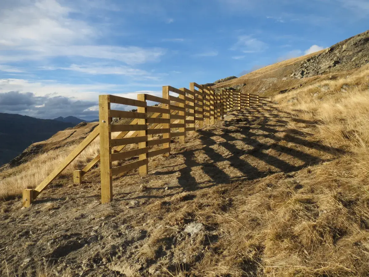 Barrière à neige en bois installée en alpage pour une station de montagne